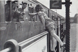 A young girl passes a bag of sweets or cigarettes to a British soldier at Wandsworth Road station.